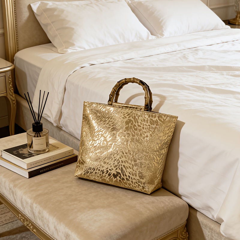 Luxury Bags Tote - 女性向けの、上品な光沢のあるメタリックゴールドのジャカード織りリーフ柄トートバッグ。竹製のハンドルを模したデザインで、大容量。
